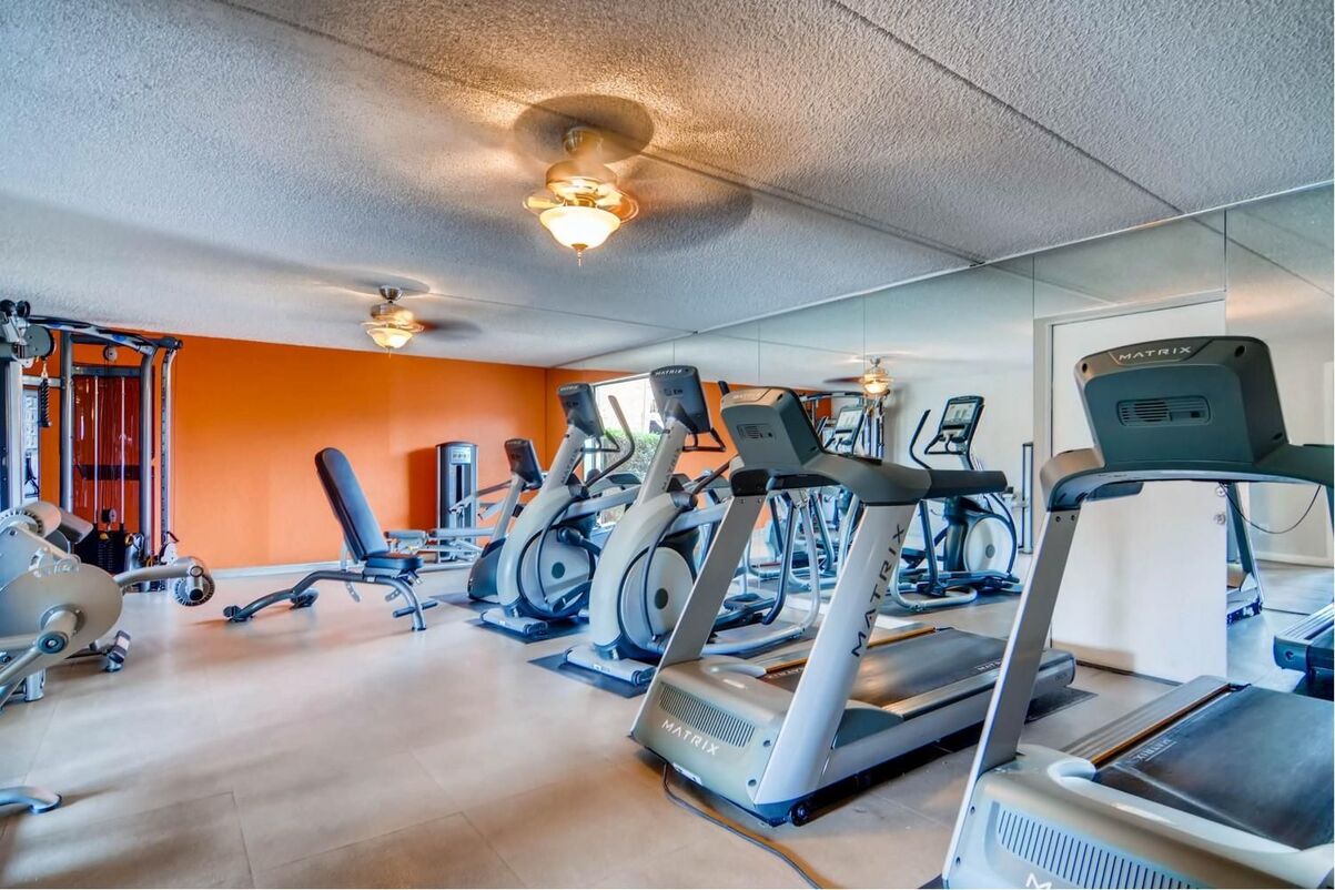 Fitness Center with cardio and strength machines, mirrors, and ceiling fans