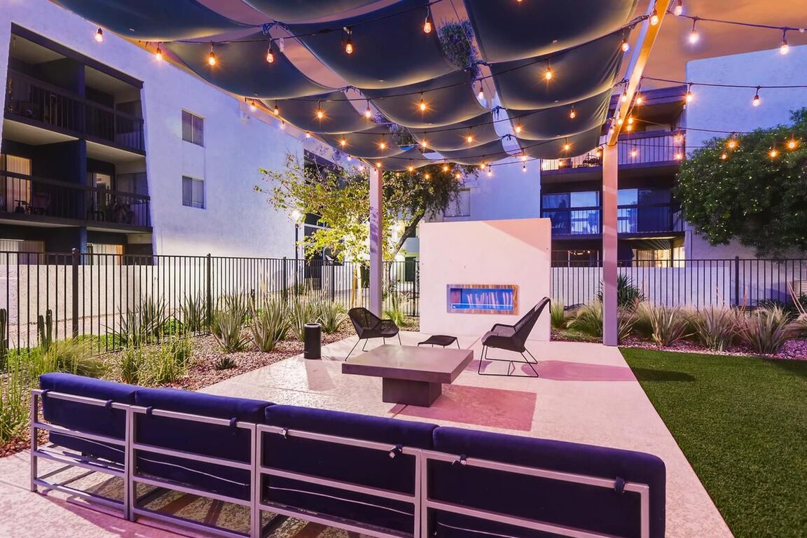 Outdoor Deck with lounge seating, fireplace, plants, and string lights