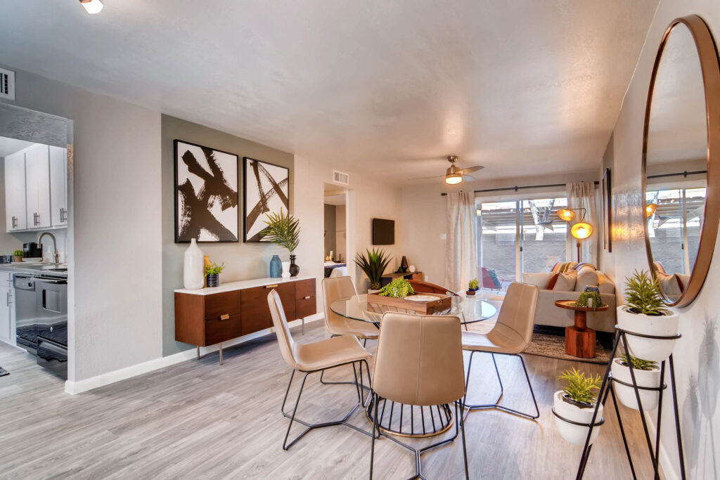 Living room and dining area in a one-bedroom apartment at The Glen at Old Town in North Scottsdale, AZ, with modern furnishings and partial kitchen view.