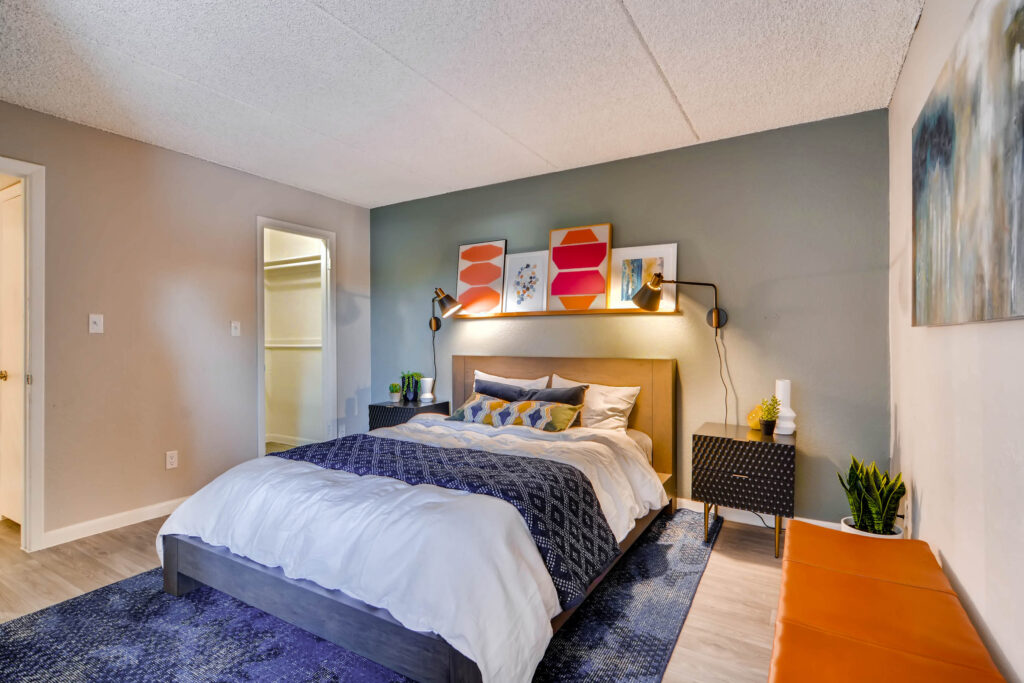 Apartment bedroom with closet, wood-style flooring, and window