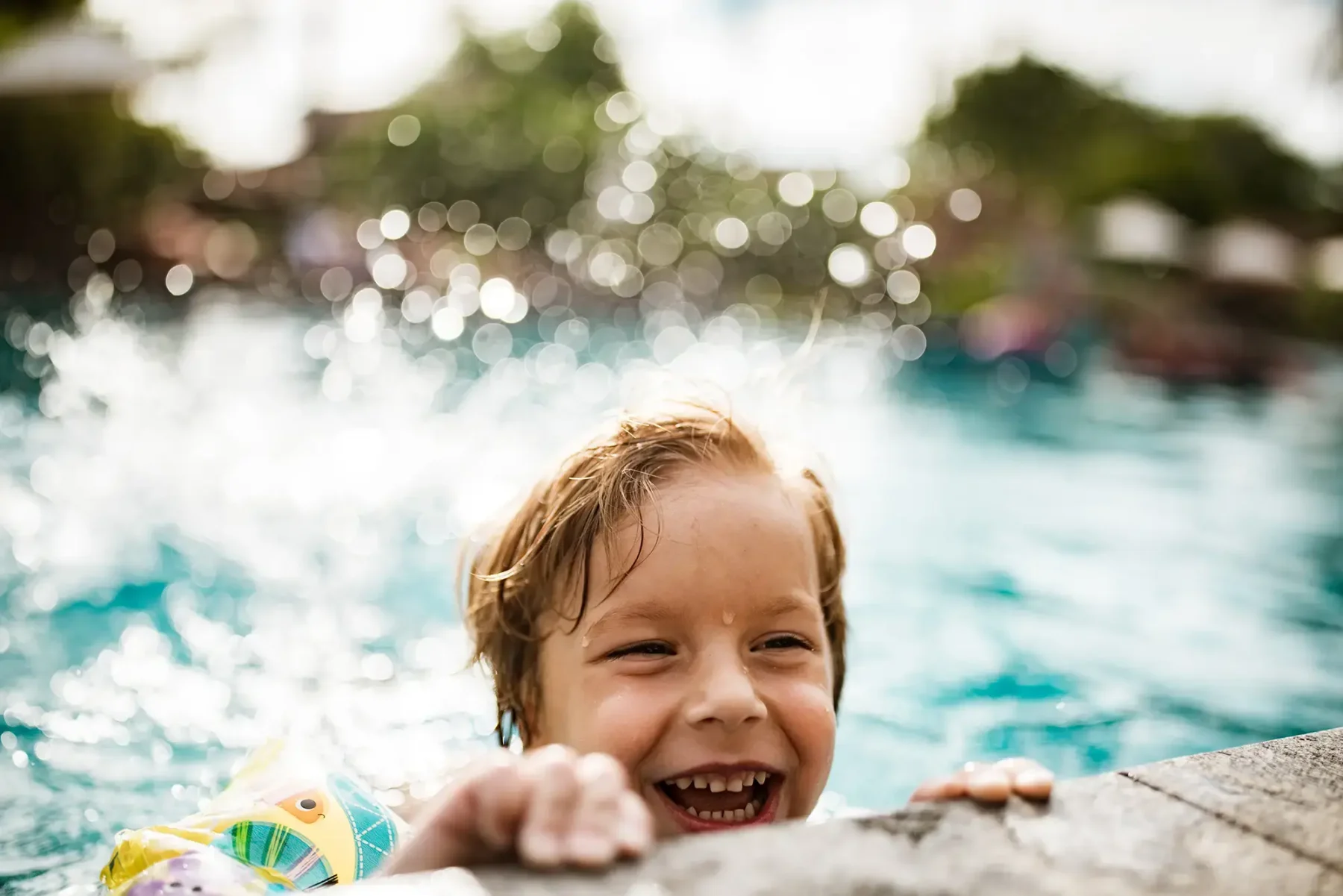 Young child splashing in swimming pool