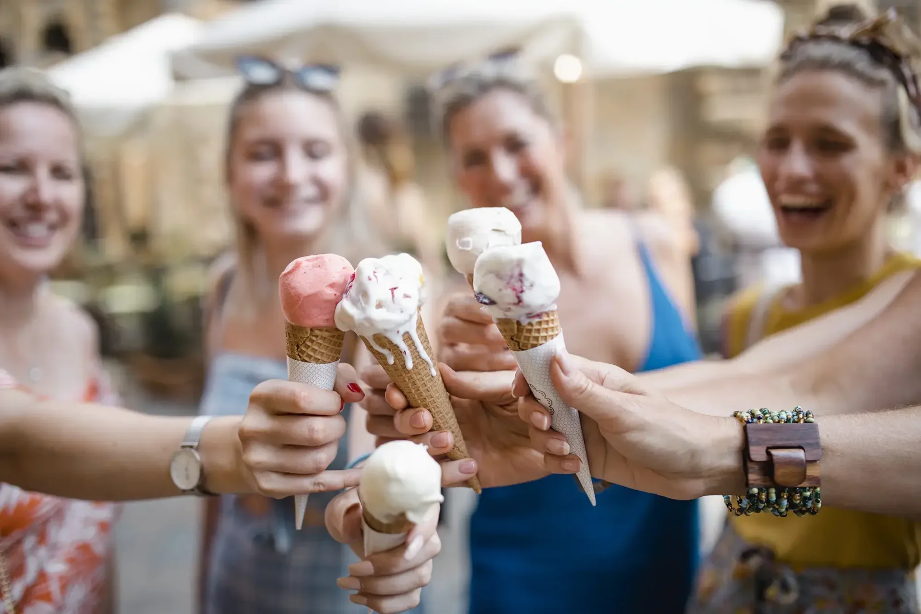 Friends holding ice cream cones outdoors