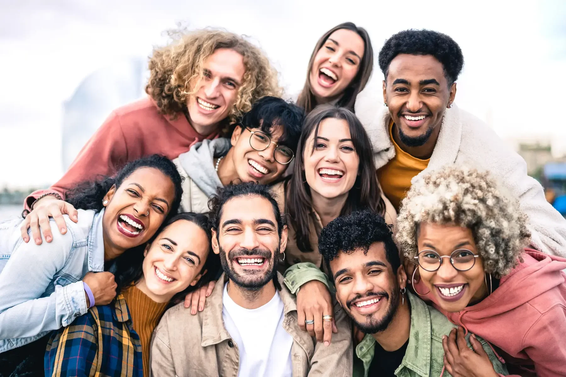 group of friends laughing and posing for a photo outdoors